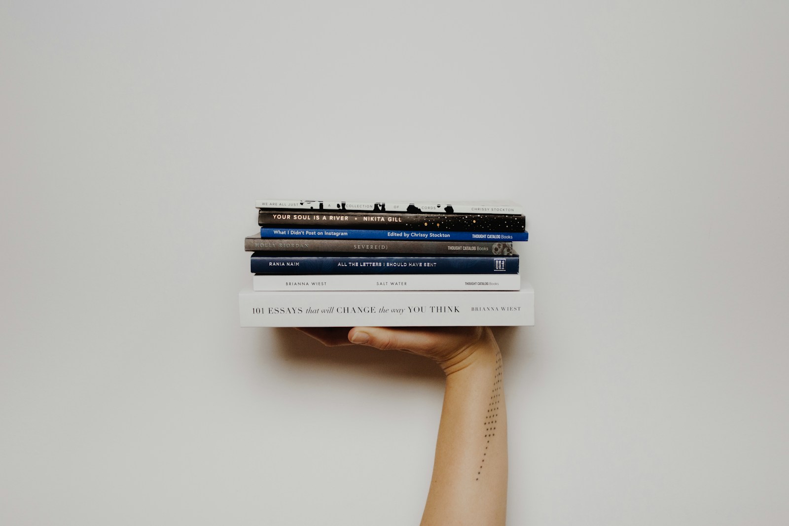 Hands holding a stack of books